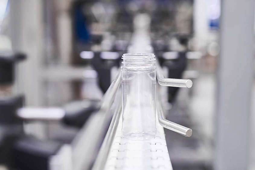 Leeres Glas wird über Förderband einer Verpackungsmaschine transportiert