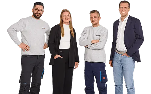 Four employees standing next to each other smiling