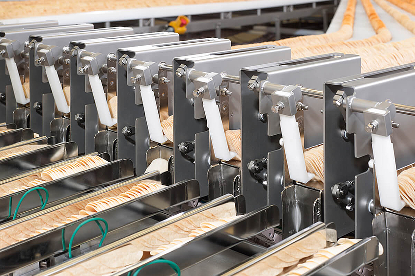 Stapelchips werden in Stapelchipsanlage an Wiegebänder übergeben