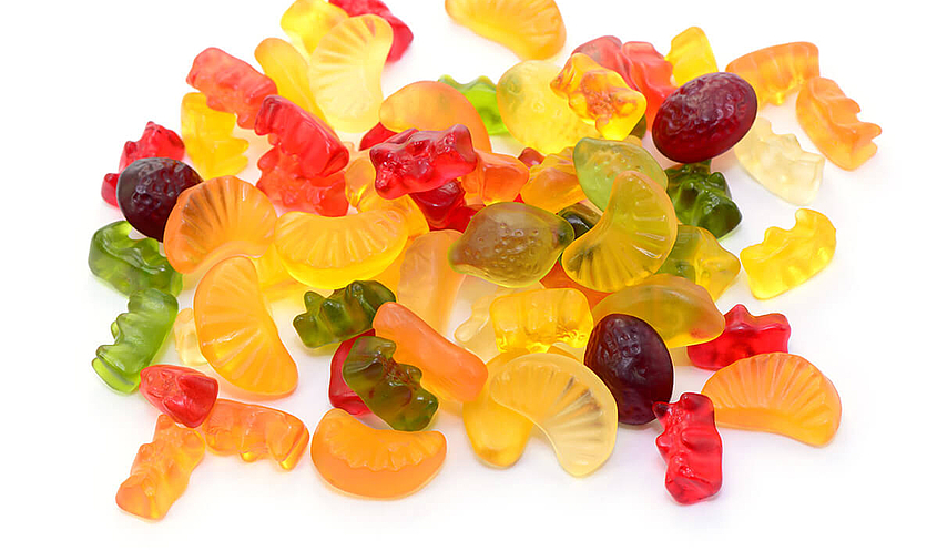Fruchtgummi und Gummibärchen liegen auf einem Haufen ohne Verpackung
