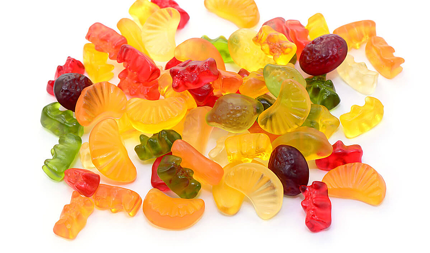 Fruchtgummi und Gummibärchen liegen auf einem Haufen ohne Verpackung