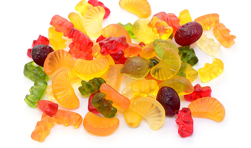 Fruchtgummi und Gummibärchen liegen auf einem Haufen ohne Verpackung