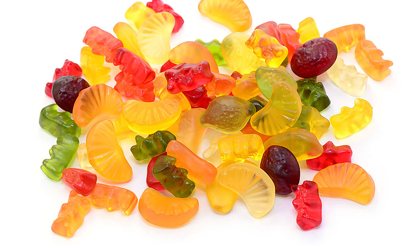 Fruchtgummi und Gummibärchen liegen auf einem Haufen ohne Verpackung