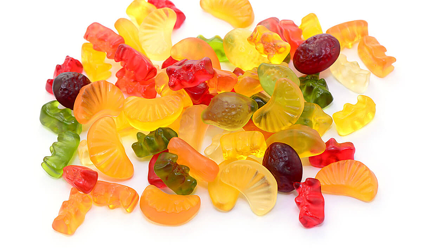 Fruchtgummi und Gummibärchen liegen auf einem Haufen ohne Verpackung